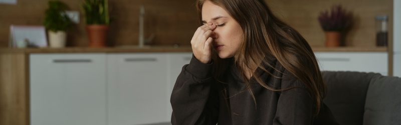Caucasian woman with pain of nasal sinus at home